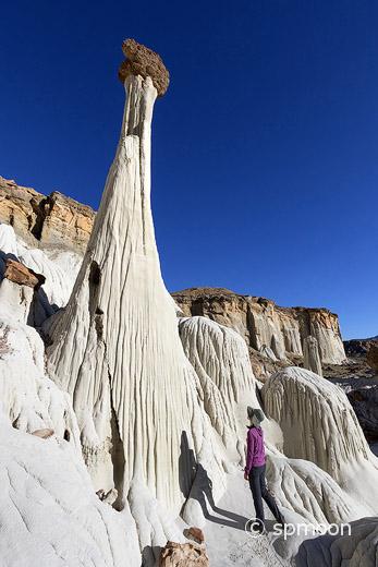 Female hiker standing next to Tower of Silence, Wahweap Hoodoos, Grand Staircase-Escalante National Monument, Utah