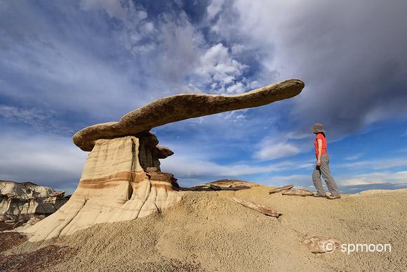 Female hiker standing next to King of Wings rock formation, New Mexico