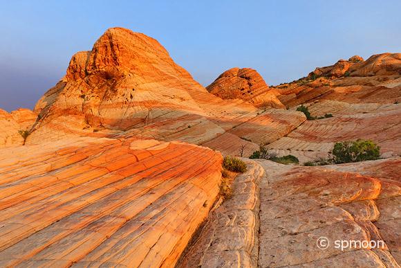 Yant Flat - red, orange, and white unusual striped rock formation in Southern Utah - glowing in sunrise.